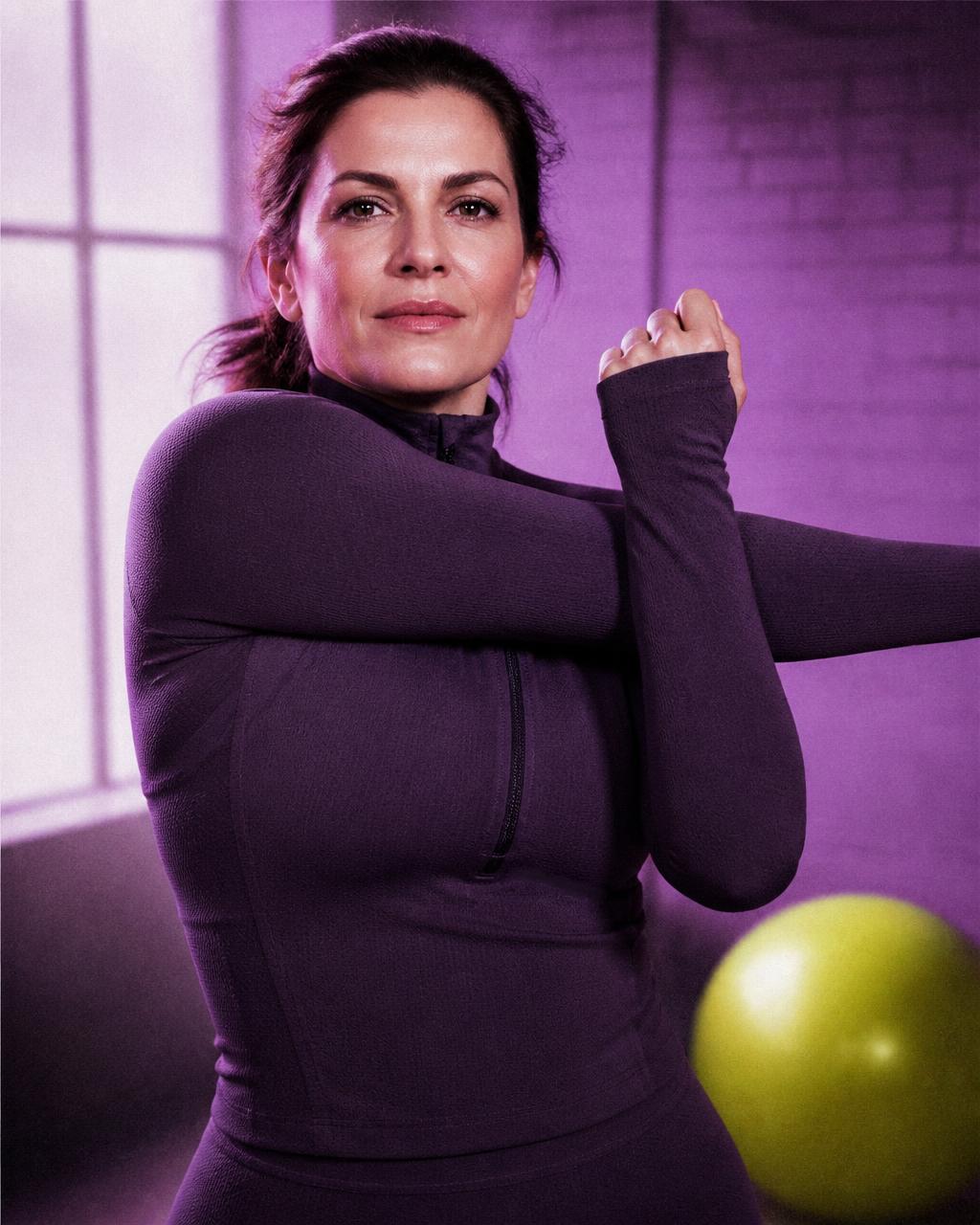 Donna adulta in movimento in uno studio luminoso, sguardo determinato
